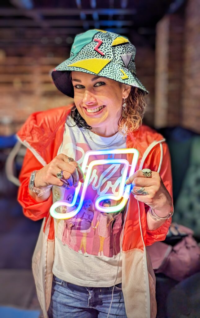 Smiling woman holding colorful music note sign.