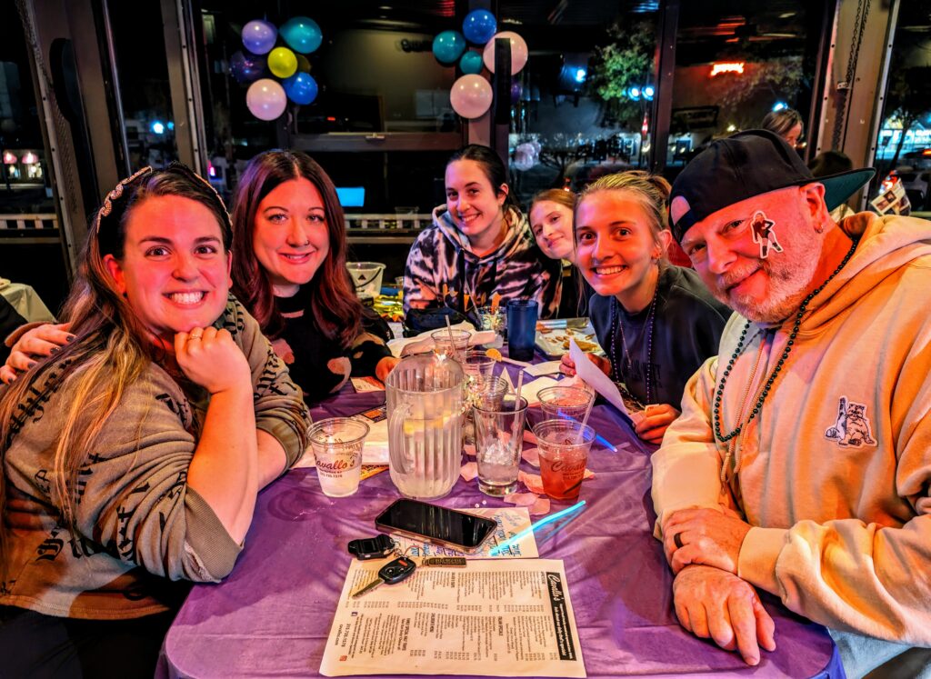 Group celebrating at a restaurant with drinks and menus.