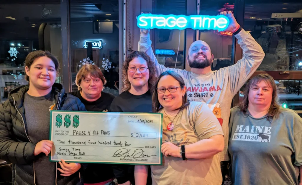 Group holding large donation check for charity event.