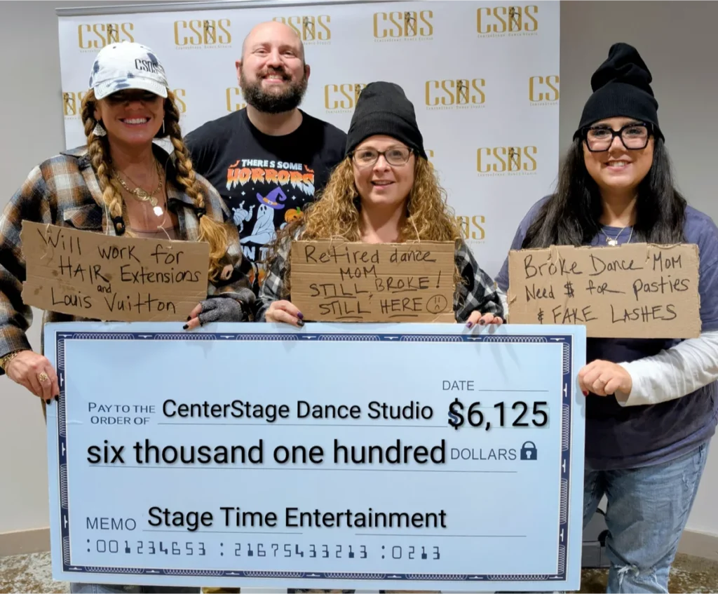 Group holding large check and humorous signs.