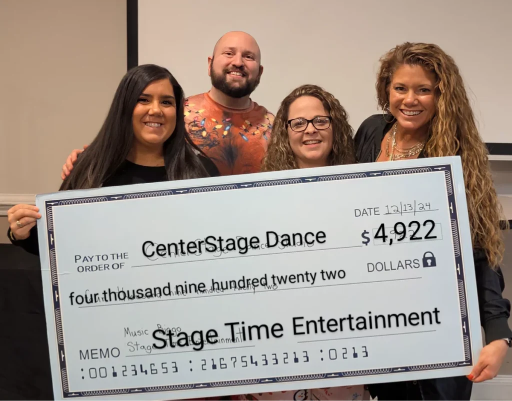 Four people holding a large check donation.
