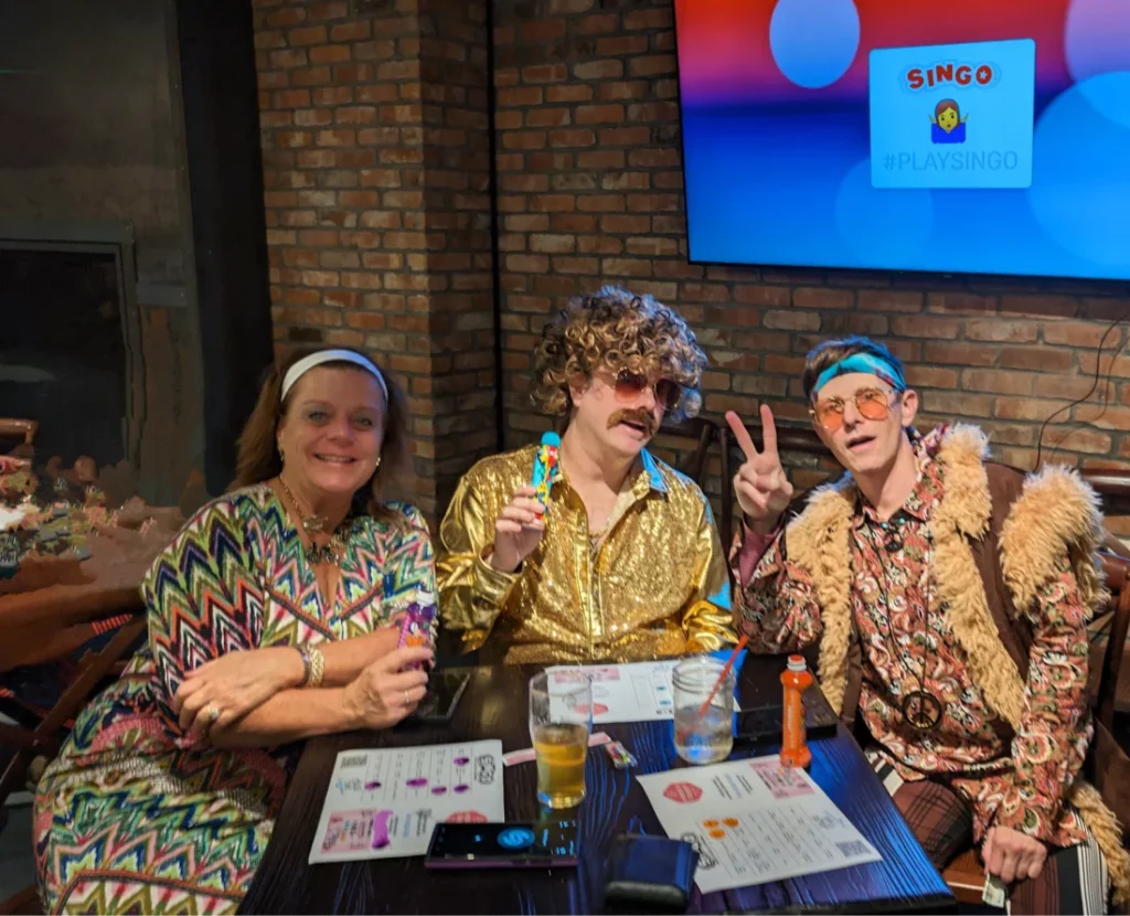 Three people in retro outfits at a bar